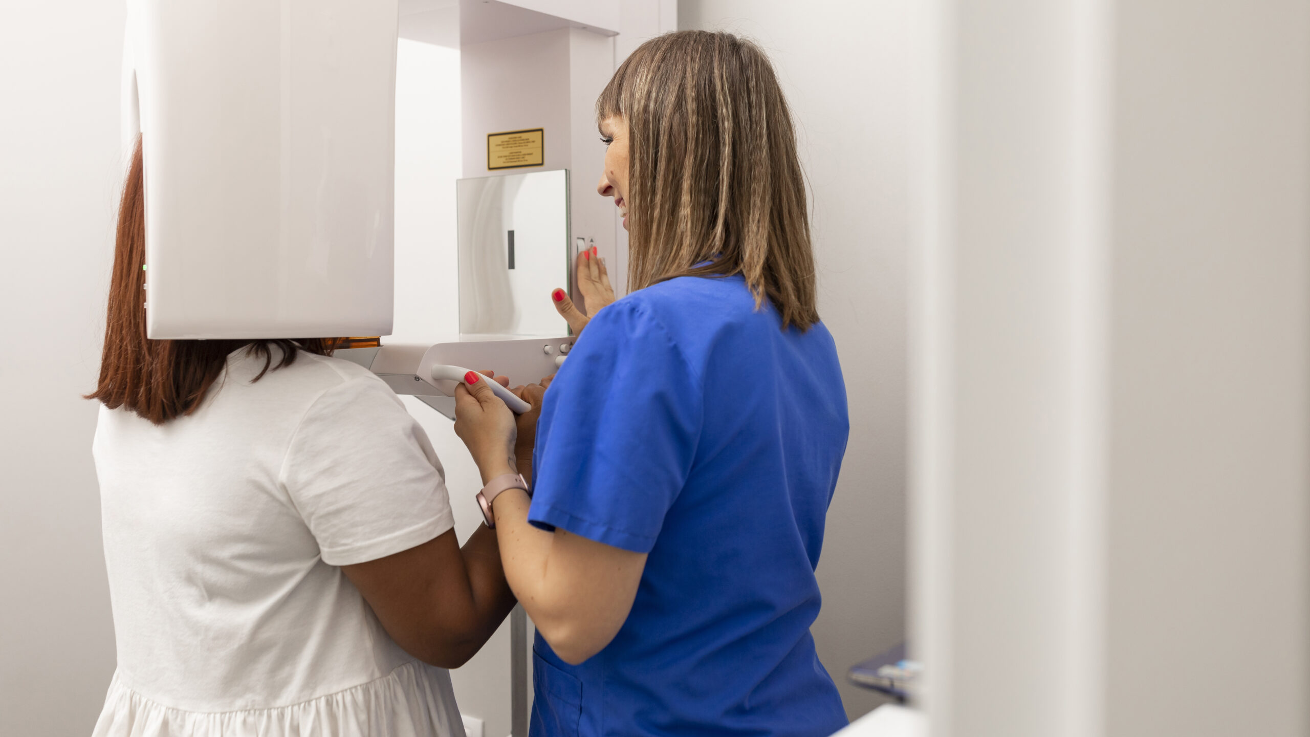 A dentist is setting up the CBCT scanner for a patient.
