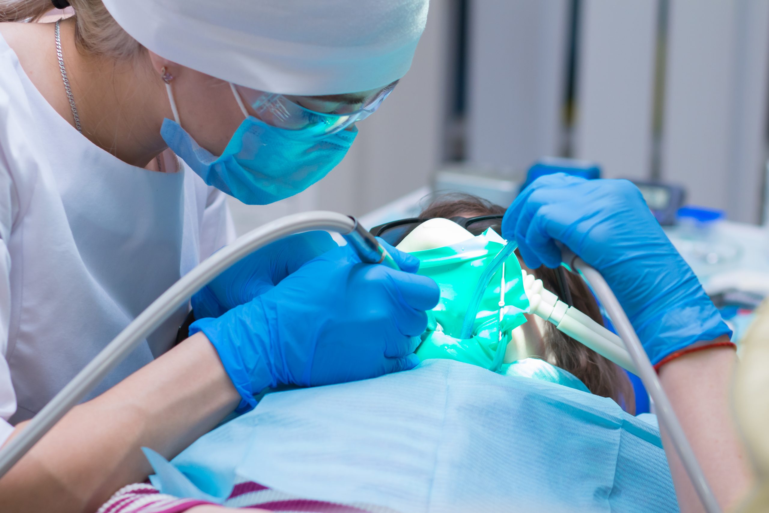 Patient being sedated by dentist in dental treatment room.