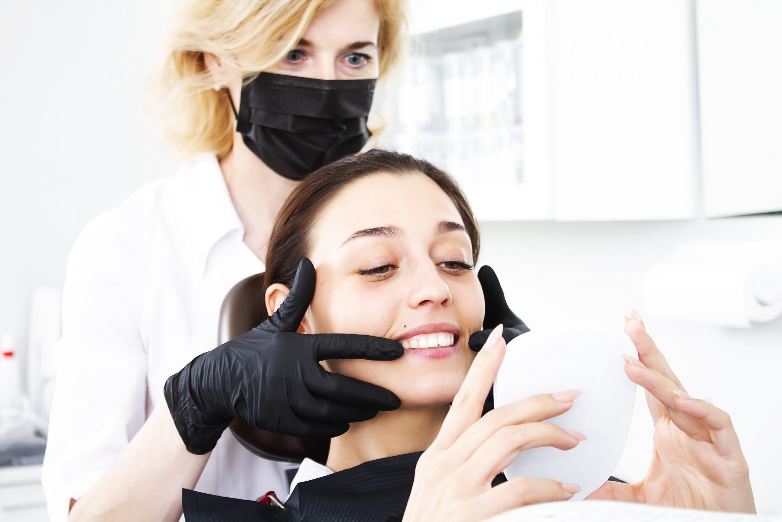 Woman gets her teeth whitened at dentist's office.